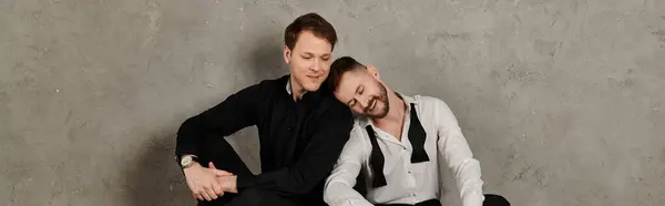 Una pareja gay cariñosa en trajes elegantes comparten un momento tierno. - foto de stock