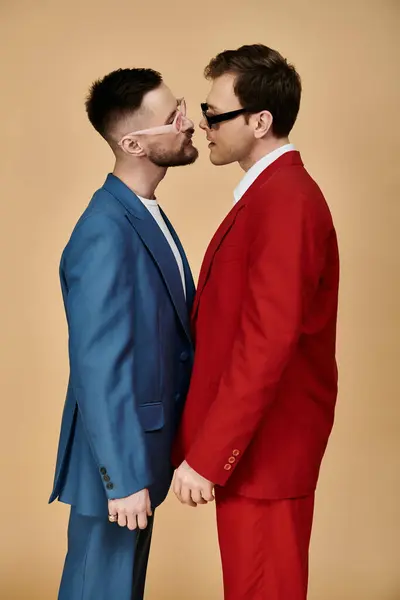 Two men in elegant suits stand close together, their eyes locked in a loving gaze. — Stock Photo