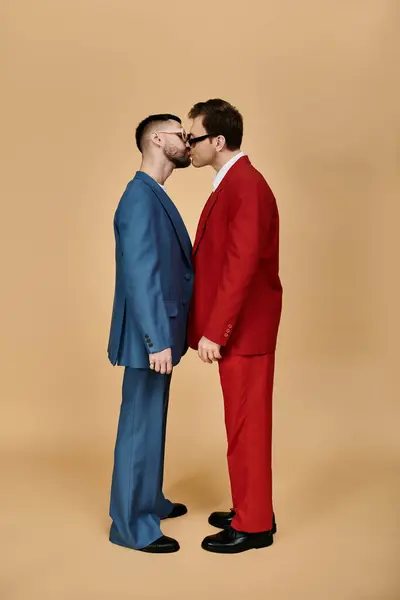 Due uomini in giacca e cravatta si avvicinano, condividendo un bacio su uno sfondo silenzioso. — Foto stock