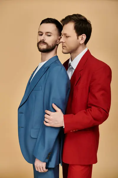 Two men in matching suits, one in blue and the other in red, posing for a photo. — Stock Photo