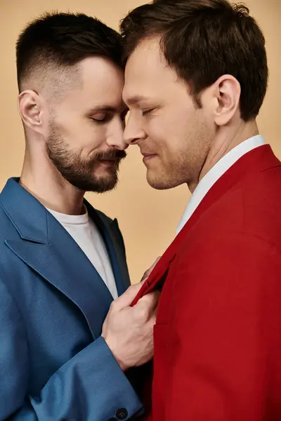 A gay couple in elegant suits, standing close and touching foreheads. — Stock Photo