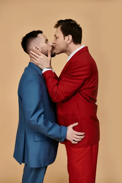 Two men in stylish suits embrace and kiss. — Stock Photo