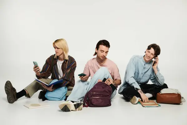 Tres jóvenes estudiantes en atuendo casual, parte de la comunidad LGBTQIA +, se conectan y charlan sobre un fondo gris. — Stock Photo