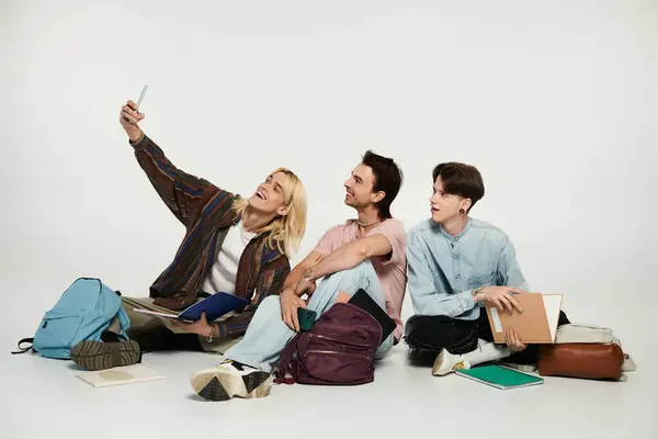 Tres jóvenes estudiantes queer con atuendo casual posan para una selfie sobre un fondo gris. — Stock Photo