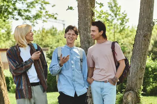 Three queer friends, are walking in a park. They are all dressed casually and seem to be having a conversation. — Stock Photo