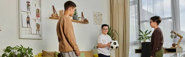 Tres chicos jugando al fútbol adentro. - foto de stock