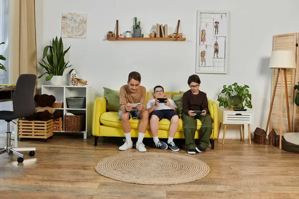 Three young boys play games on a yellow sofa in a living room. — Stock Photo