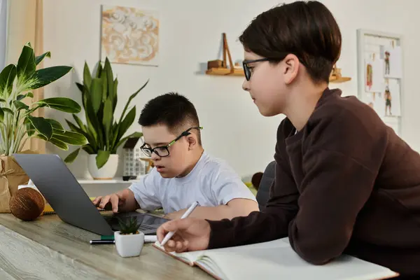 Two boys are working together on a laptop at a table. — Stock Photo