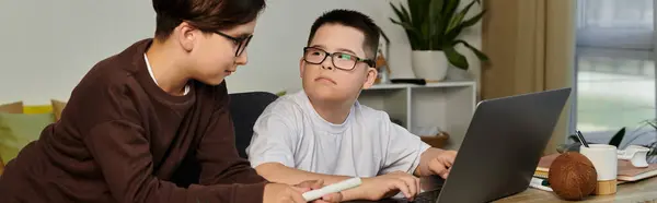 Dos niños, uno con síndrome de Down, están usando una computadora portátil en casa. — Stock Photo