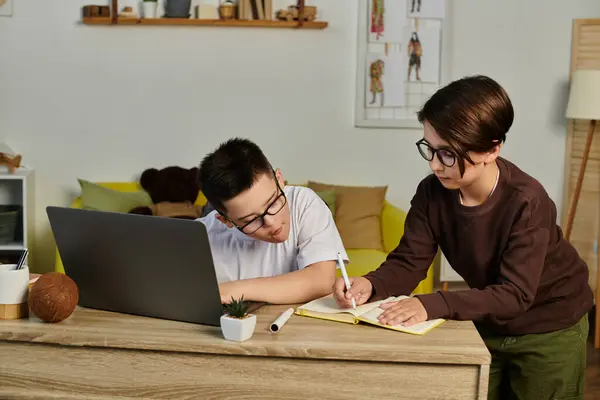Two young boys, one with Down syndrome, study together at home. — Stock Photo