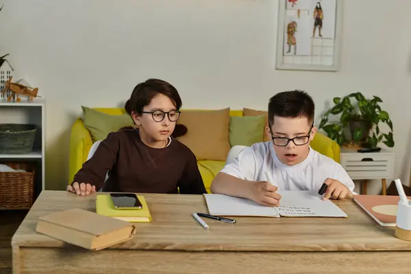 Two young boys study together at a table in a living room. — Stock Photo