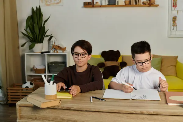 Zwei kleine Jungen, einer mit Down-Syndrom, arbeiten zu Hause an den Hausaufgaben. — Stockfoto