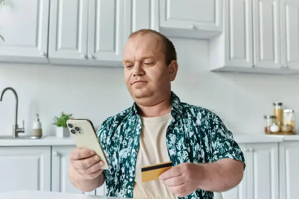 Un uomo con inclusività effettua un acquisto online utilizzando il telefono e la carta di credito. — Foto stock