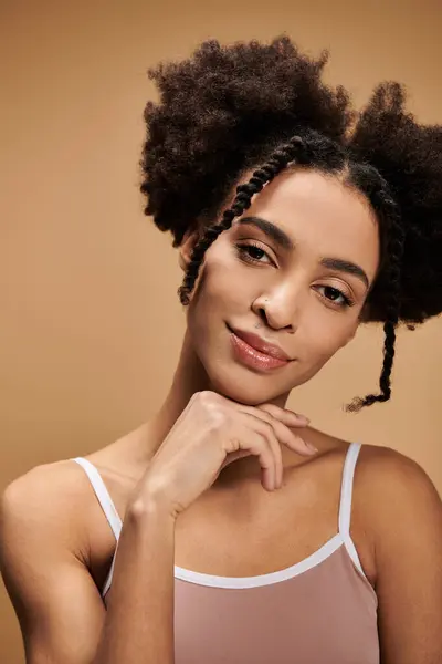 Uma jovem mulher com pele escura e cabelo afro olha diretamente para a câmera, sua mão descansando suavemente em seu queixo. — Fotografia de Stock