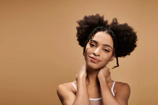Uma bela jovem afro-americana com um penteado afro posa contra um fundo bege — Fotografia de Stock