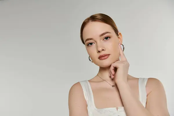 A young woman poses with a thoughtful expression, her hand gently resting on her cheek. — Stock Photo