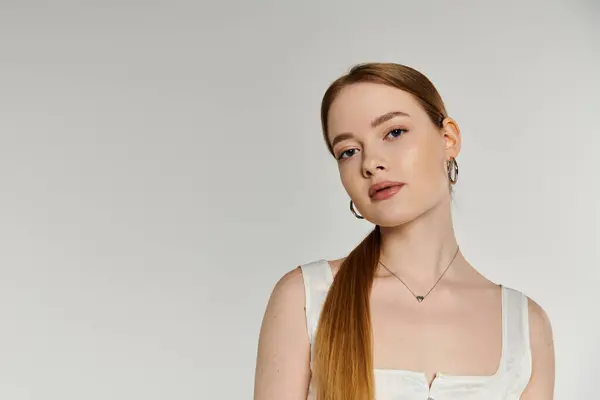 Donna dai capelli rossi in camicia bianca sembra fiducioso sulla macchina fotografica. — Foto stock