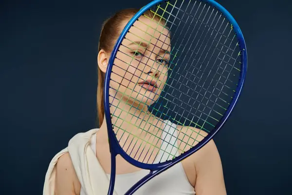 Young woman gracefully poses with tennis racket against bold backdrop. — Stock Photo