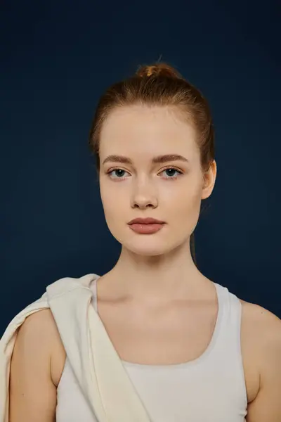 Eine junge Frau mit roten Haaren posiert vor marineblauem Hintergrund. — Stock Photo