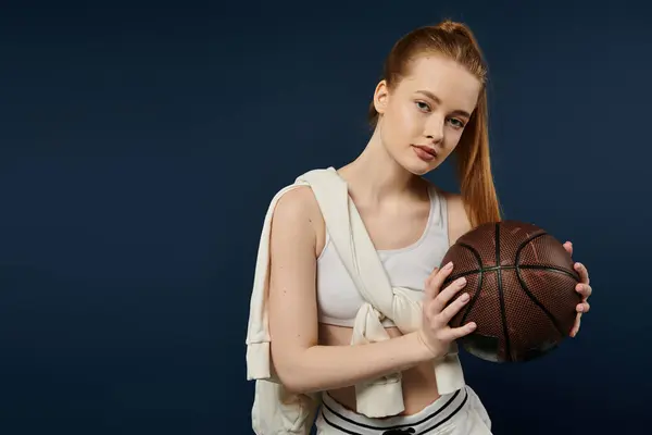Eine junge Frau posiert vor einer leuchtend blauen Kulisse und hält einen Basketball in den Händen. — Stockfoto
