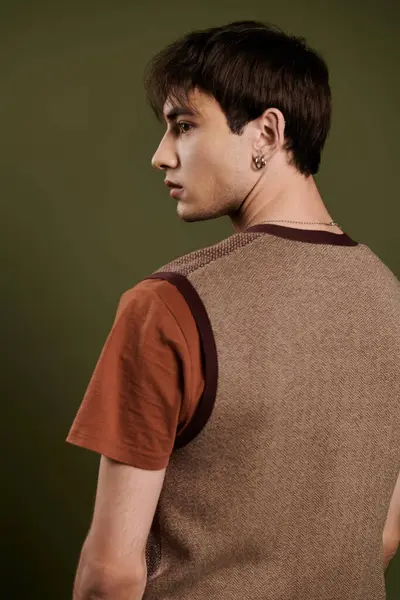 A stylish man poses for a portrait wearing a brown vest and a rust-colored t-shirt. — Stock Photo