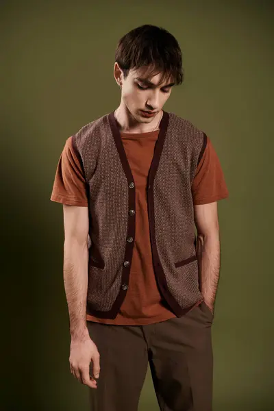 A handsome man in a brown knitted vest poses against a vibrant green backdrop. — Stock Photo