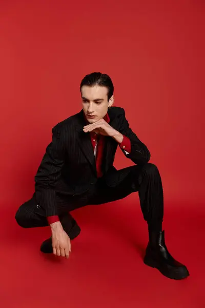 Elegant man in suit and tie posing against vibrant background. — Stock Photo