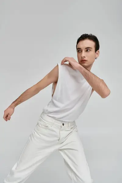 Um homem elegante em roupas brancas posa contra um fundo branco. — Fotografia de Stock