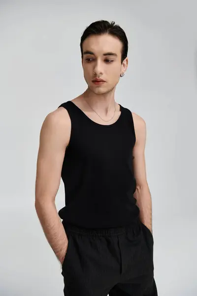 Un homme en débardeur noir pose sur fond blanc. — Photo de stock
