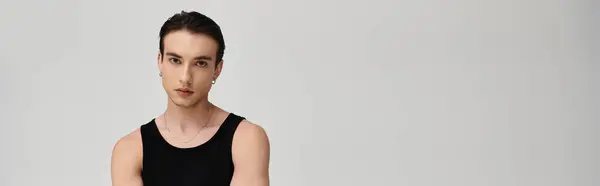 A man with short dark hair poses in a black tank top against a white background. — Stock Photo