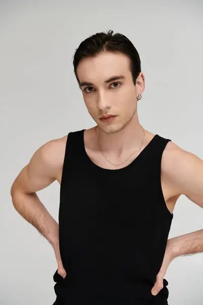 A man poses confidently in a black tank top against a white background. — Stock Photo