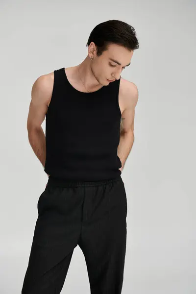 A man in a black tank top poses against a white backdrop. — Stock Photo
