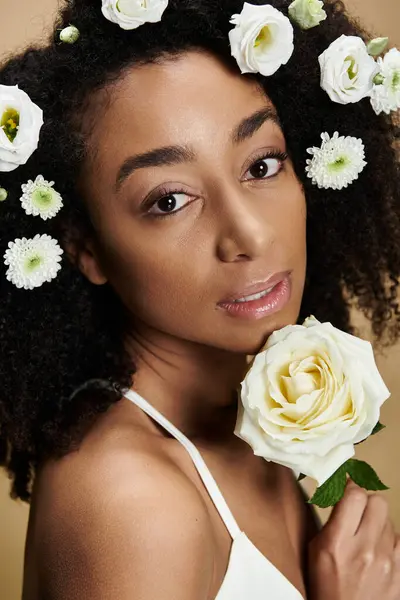 A close-up portrait of a beautiful African American woman with natural makeup and flowers in her hair. — Stock Photo