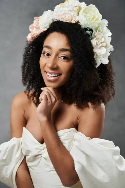 A beautiful African American bride in a white wedding dress smiles brightly, wearing a floral crown. — Stock Photo