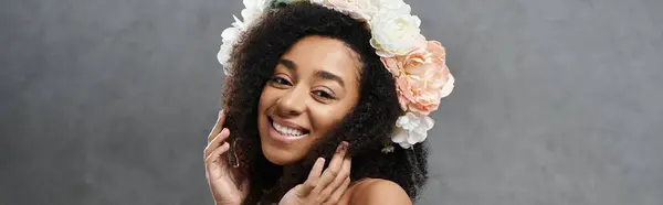 Красивая афроамериканская невеста с цветочной короной ярко улыбается на сером фоне. — стоковое фото