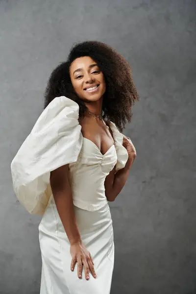 A beautiful African American bride in a white wedding dress against a grey background. — Stock Photo
