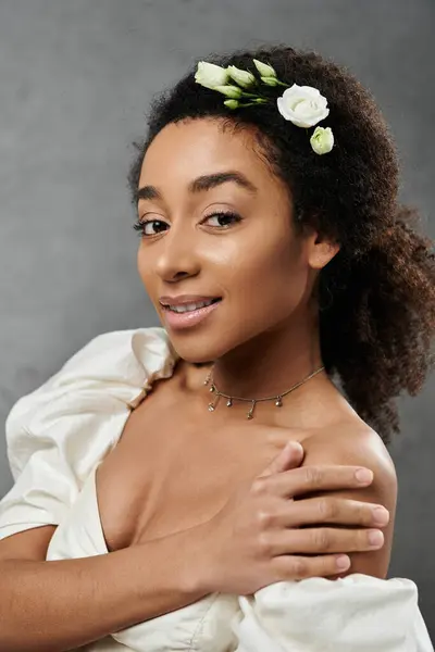 A beautiful African American bride in a white wedding dress smiles, wearing a floral crown and a delicate necklace. — Stock Photo