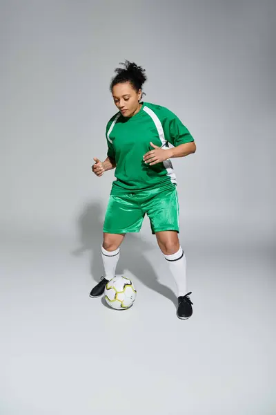 Una donna in uniforme da calcio verde controlla abilmente la palla. — Foto stock