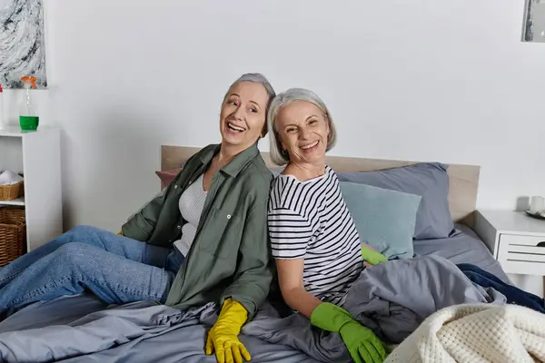 Duas mulheres maduras em traje casual limpar seu apartamento moderno. — Fotografia de Stock
