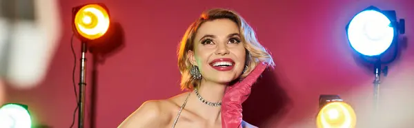 Woman in bright attire smiles for portrait with colorful lights. — Stock Photo