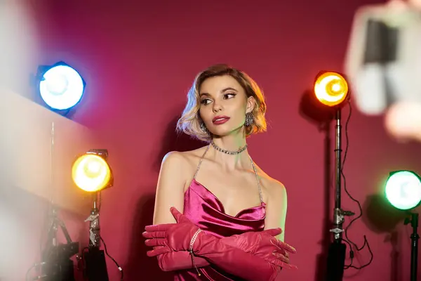 Woman in pink dress poses for a photo shoot with studio lights. — Stock Photo