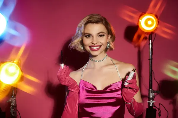 Eine Frau in rosa Kleid und roten Handschuhen posiert in einem Atelier mit Make-up. — Stockfoto