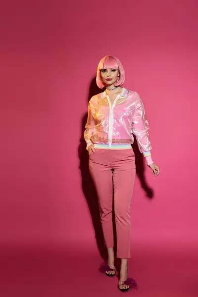 A woman in pink clothing and a pink wig poses against a pink background. — Stock Photo