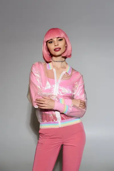 A woman with pink hair wears a vibrant pink outfit, including a sheer, rainbow-trimmed jacket. — Stock Photo