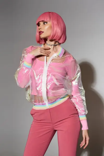 Una mujer con el pelo rosa lleva una chaqueta transparente y pantalones rosas. — Stock Photo