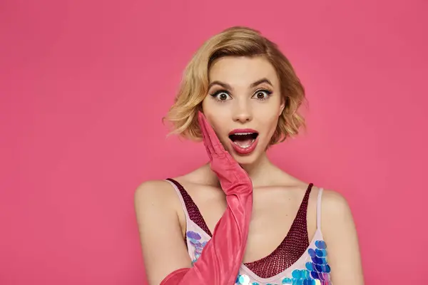 Uma mulher de lantejoulas e luvas rosa parece surpreso. — Fotografia de Stock