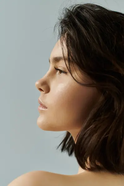Illuminated by soft light, a woman with short, dark hair gazes into the distance. — Stock Photo