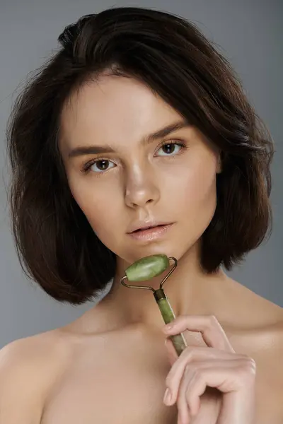 A woman uses a jade roller on her skin. — Stock Photo