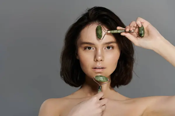 Una donna usa un rullo di giada sul viso, un trattamento di bellezza popolare. — Foto stock