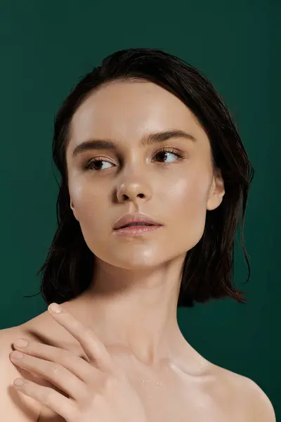Une belle femme aux cheveux foncés pose sur un fond vert vif. — Photo de stock